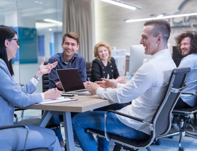 Group of a young business people discussing business plan at modern startup office building